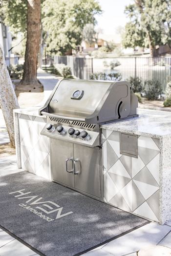 a stainless steel barbecue grill in a backyard